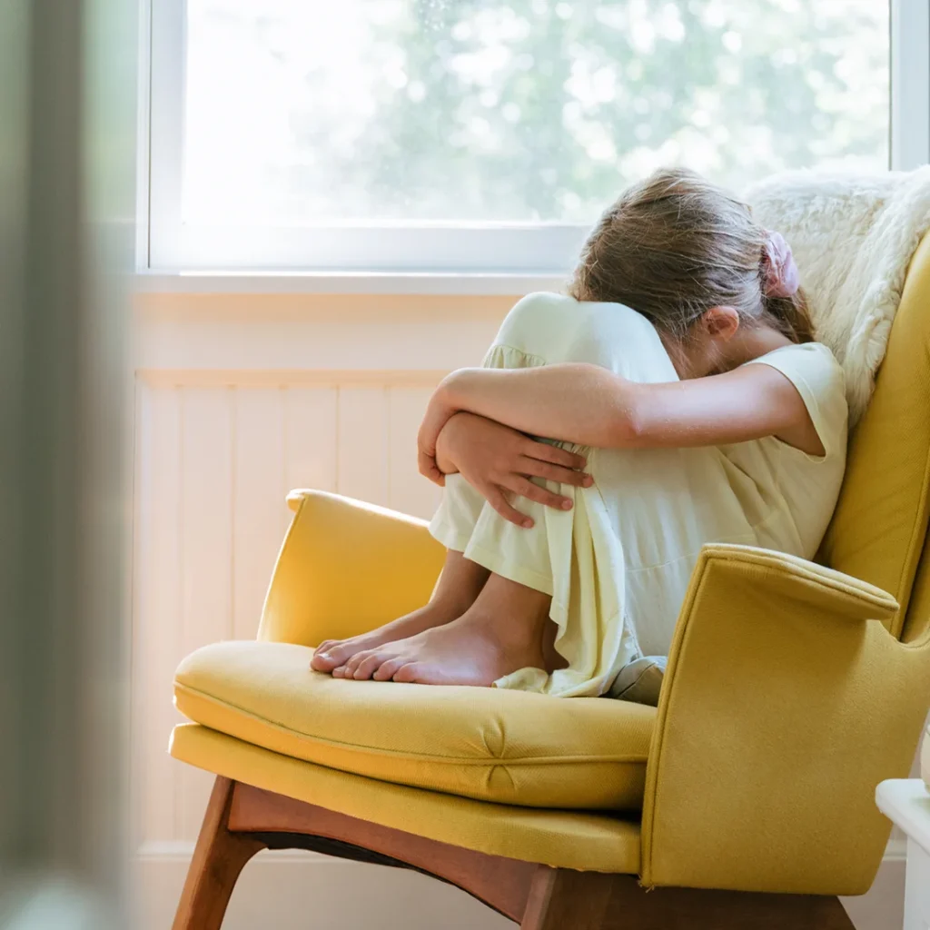 Girl with autism sitting on chair in isolated manner